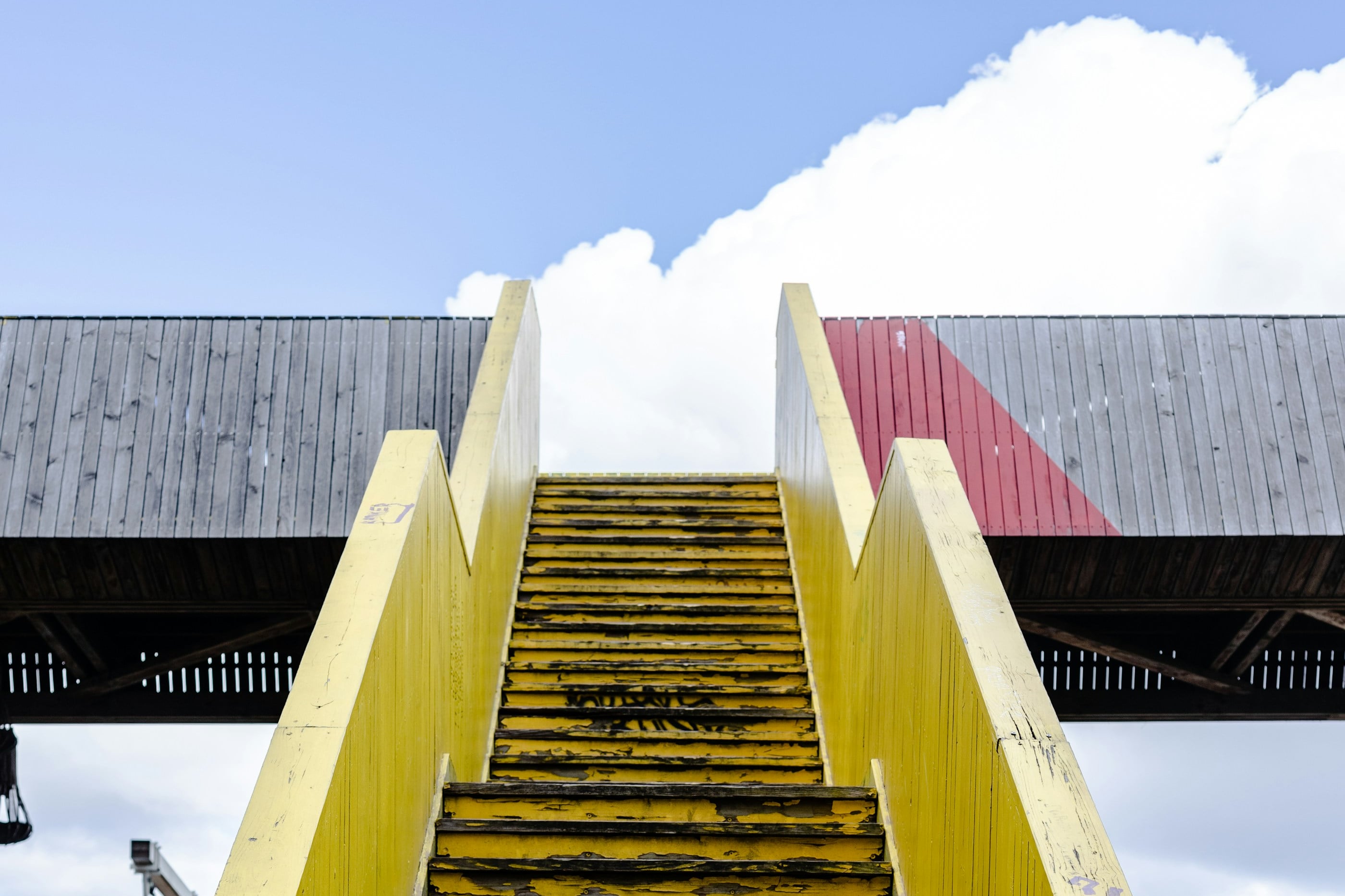 Gelbe Treppe, die in den Himmel zu einer weißen Wolke führt
